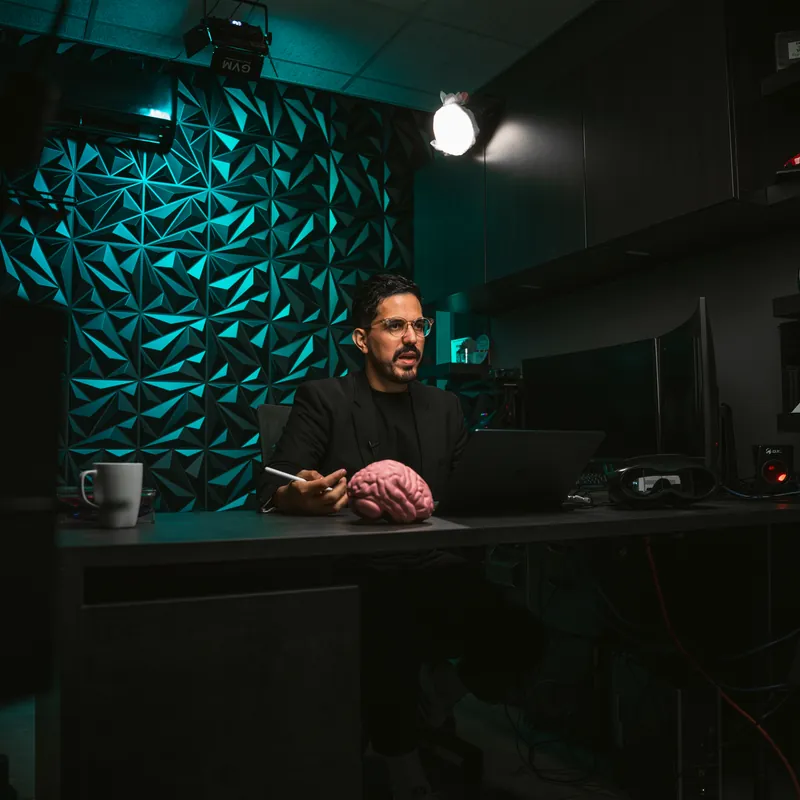Presentador en el set oscuro con pared texturizada